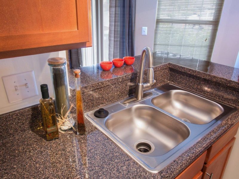 This image shows the premium apartment feature, particularly the kitchen island featuring its fully equipped kitchen with granite-inspired countertops.