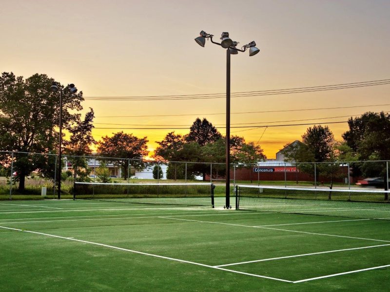 This image exhibits the premium community amenities, particularly the lighted tennis court featuring its green floor design and its spacious area that was ideal for a great tennis game.
